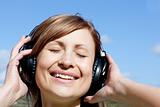 Smiling woman listenng music outdoors