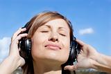 Beautiful woman listenng music outdoors