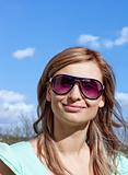 Smiling blond woman with sunglasses outdoors