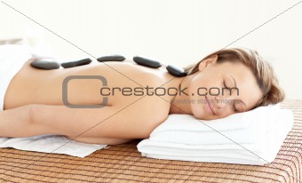 Radiant woman with hot stones on her back 