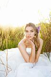 Attractive Young Bride Sitting in the Grass