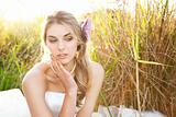 Attractive Young Bride Sitting in the Grass