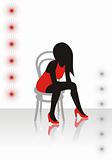 The beautiful girl in a red dress sits on a chair