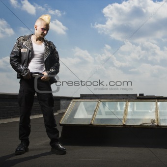 Punk standing on roof.