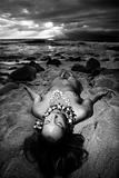 Nude woman ying on beach.