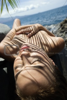 Nude woman sunbathing.