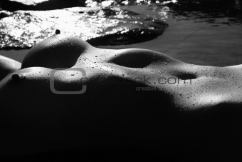 Nude woman lying water.