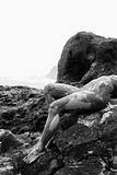 Muddy nude female on rock.