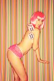 Topless woman in pink wig.