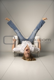 Woman upside down in chair.