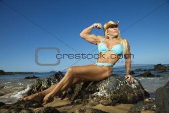 Woman bodybuilder at beach.