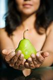 Woman holding pear.