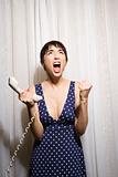 Woman holding telephone screaming.