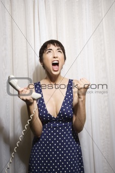 Woman holding telephone screaming.