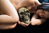 Nude woman holding skull.