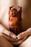 Nude woman holding Buddha.