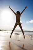 Girl jumping on beach.