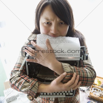 Woman holding typewriter.