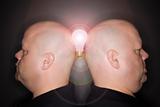 Twin men profile with lightbulb.