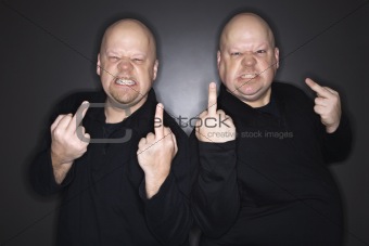 Twin men making obscene gesture.