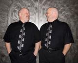 Twin bald men laughing.