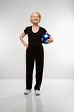 Senior woman holding soccer ball.