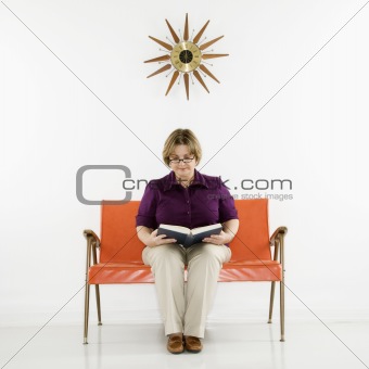 Woman sitting reading book.