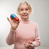 Woman holding oversized pill.