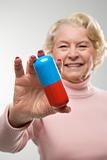 Woman holding oversized pill.