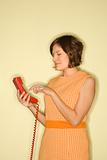 Woman dialing telephone.