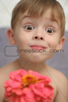 Emotions of the boy with a pink flower in a hand