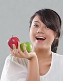young pretty girl smiles while holding an apples