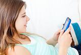 Delighted woman writing a text message