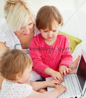 Cheerful family having fun with a laptop in the living-room 