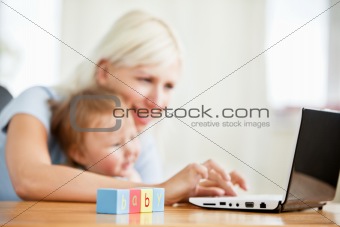 Smiling woman surfing on the internet with her girl in the livin