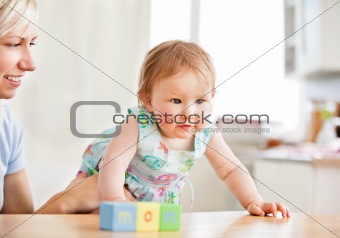 Smiling woman playing with her girl in the living-room 