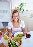 Cute woman eating a salad in the kitchen