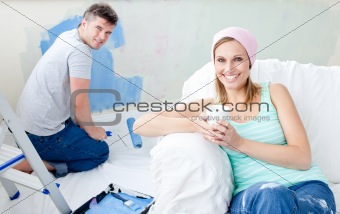 Bright woman relaxing boyfriend paint the room