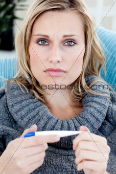 Young woman with a thermometer looking at the camera