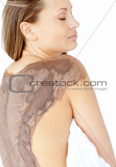 Portrait of a bright woman enjoying a mud skin treatment