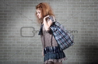 Tired redhaired woman with shopping bag. 