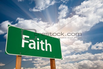 Faith Green Road Sign with Dramatic Clouds, Sun Rays and Sky.
