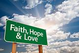 Faith, Hope and Love Green Road Sign with Dramatic Clouds, Sun Rays and Sky.