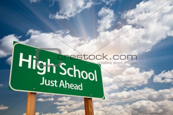 High School Just Ahead Green Road Sign with Dramatic Clouds, Sun Rays and Sky.