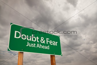 Doubt and Fear Just Ahead Green Road Sign with Dramatic Storm Clouds and Sky.