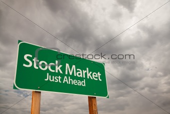 Stock Market Just Ahead Green Road Sign with Dramatic Storm Clouds and Sky.