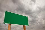 Blank Green Road Sign over Dramatic Stormy Clouds - Ready for your own message and Room For Copy on the Clouds.