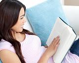 Attractive woman reading a book on sofa