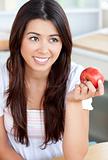 Attractive woman eating an apple in kitchen