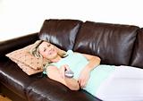 Slack woman lies on sofa and watches TV